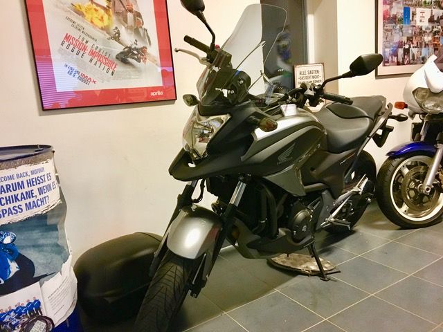 Zwei Motorräder sind nebeneinander in einem Raum geparkt.