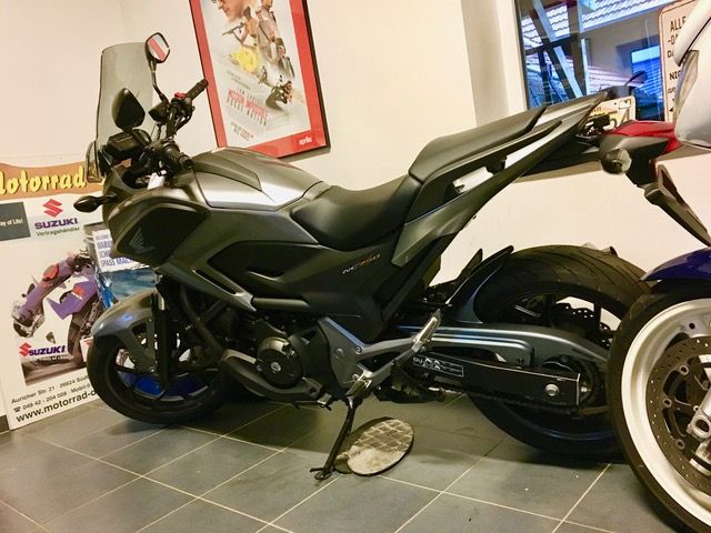 Ein Motorrad ist vor einem Schild mit der Aufschrift „Motorrad“ geparkt