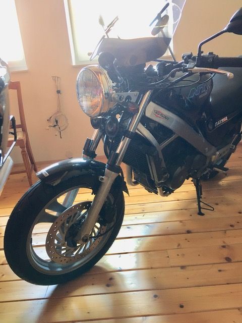 Ein Motorrad ist auf einem Holzboden in einem Raum geparkt