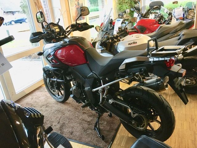 Ein Motorrad ist zusammen mit anderen Motorrädern in einem Ausstellungsraum geparkt.