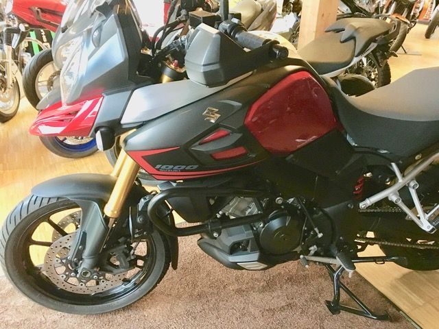 Ein rot-schwarzes Motorrad steht in einem Ausstellungsraum