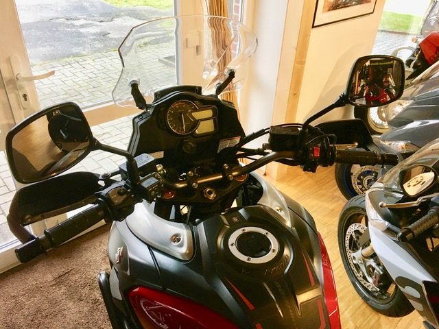 Ein schwarz-rotes Motorrad ist in einem Raum geparkt