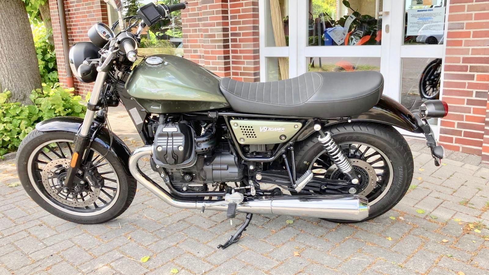 Vor einem Backsteingebäude ist ein Motorrad geparkt.