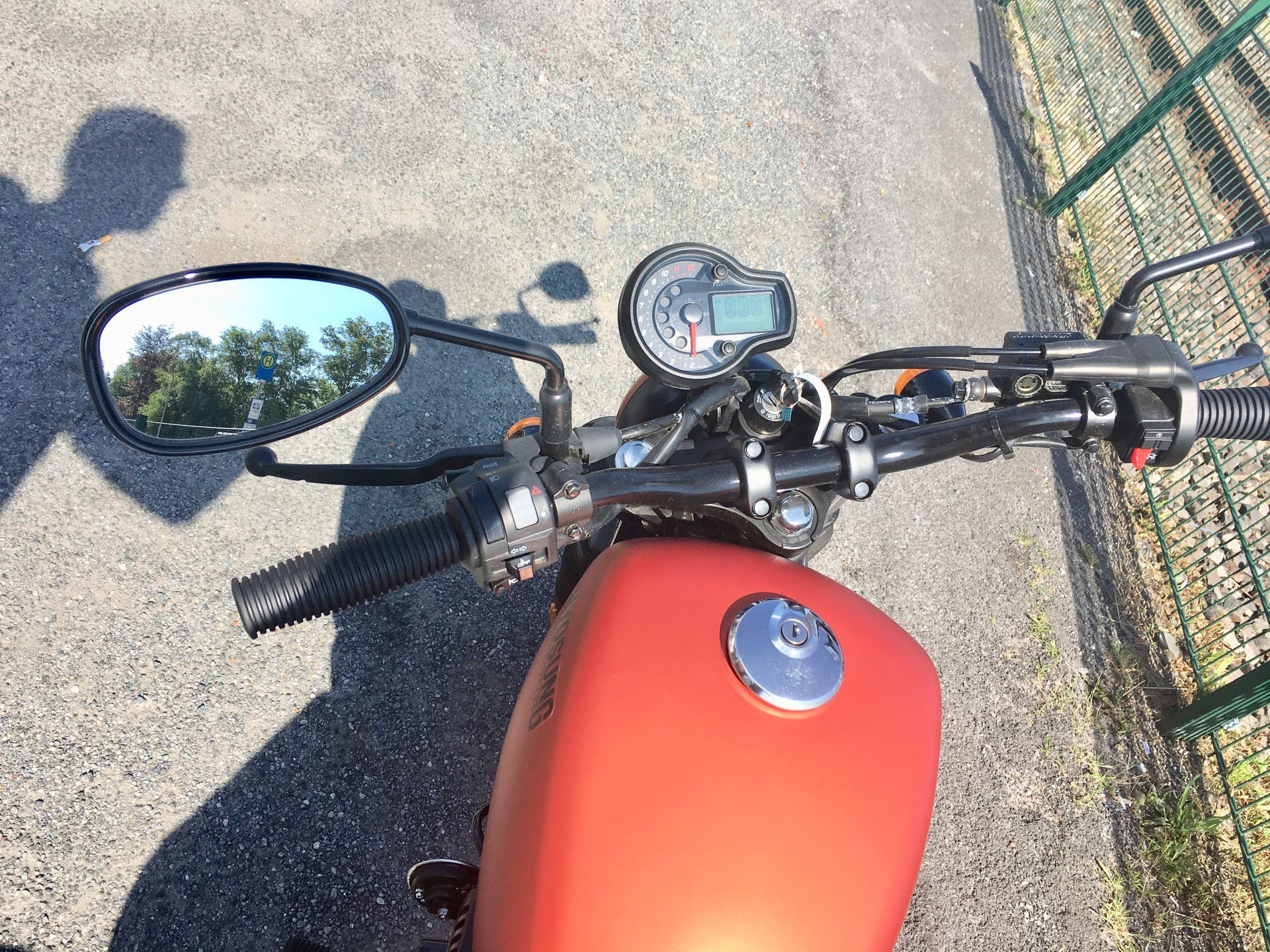 Ein rotes Motorrad ist am Straßenrand geparkt.