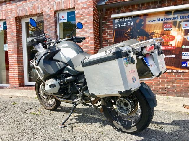 Vor einem Backsteingebäude ist ein Motorrad geparkt.