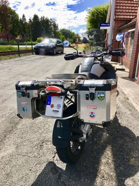 Ein Motorrad ist am Straßenrand neben einem Gebäude geparkt.