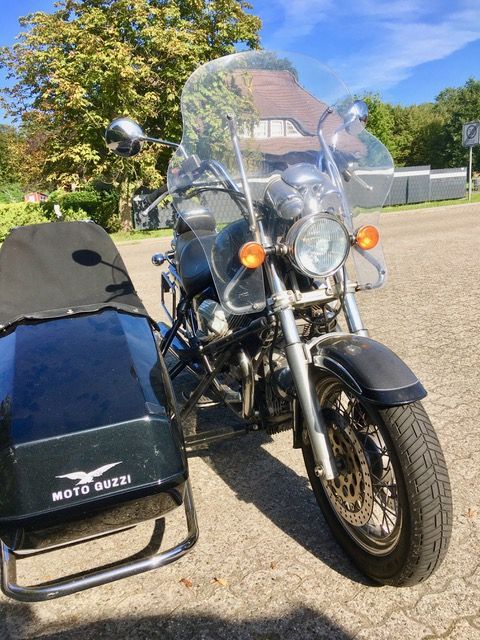 Ein Motorrad mit Beiwagen, auf dem Moto Guzzi steht