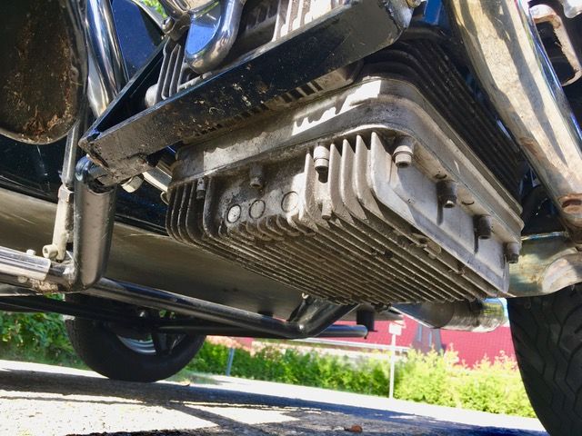 Eine Nahaufnahme des Motors eines am Straßenrand geparkten Motorrads.