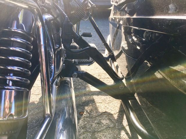 Auf einem Parkplatz steht ein Motorrad neben einem anderen Motorrad.