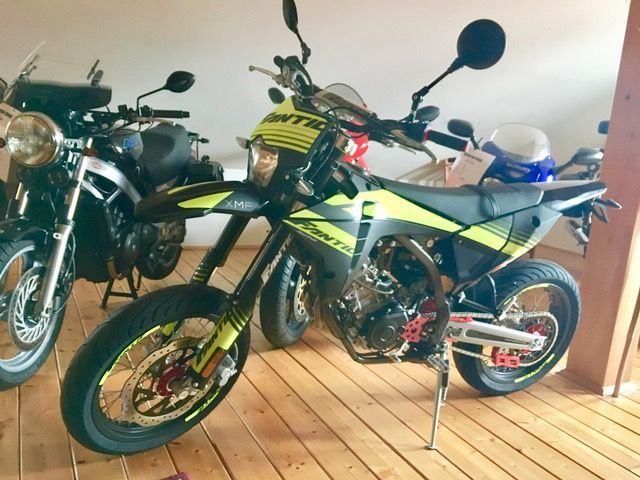 Mehrere Motorräder sind auf einem Holzboden geparkt