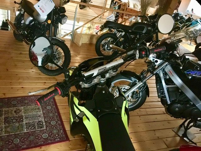 Eine Reihe von Motorrädern sind auf einem Holzboden aufgereiht