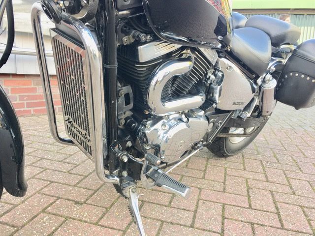 Eine Nahaufnahme eines Motorradmotors auf einem Ziegelsteinpflaster.