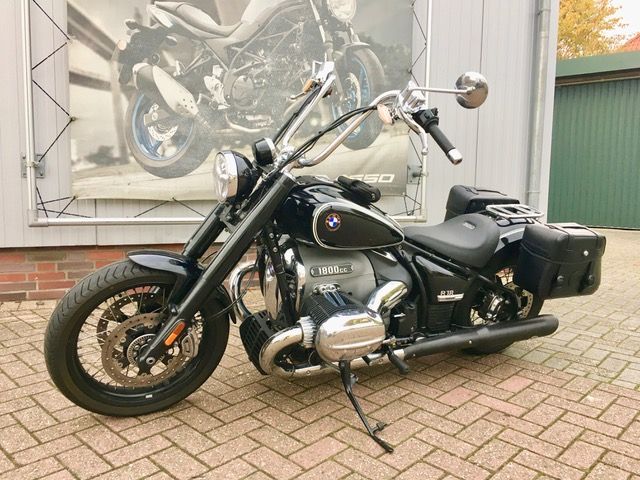 Vor einem Backsteingebäude parkt ein schwarzes Motorrad.