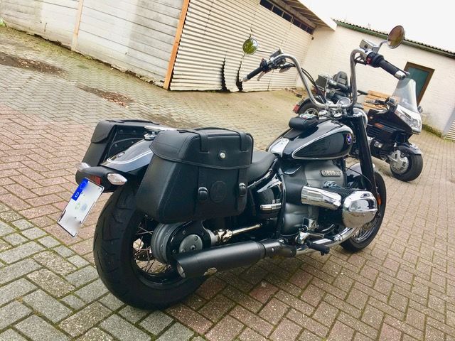 Auf einem gepflasterten Gehweg vor einem Gebäude ist ein Motorrad geparkt.