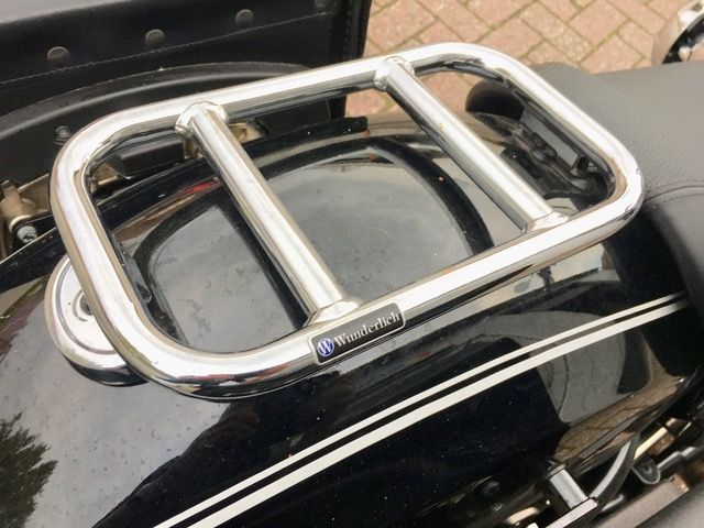 Ein schwarzes Motorrad mit einem verchromten Gepäckträger auf der Rückseite