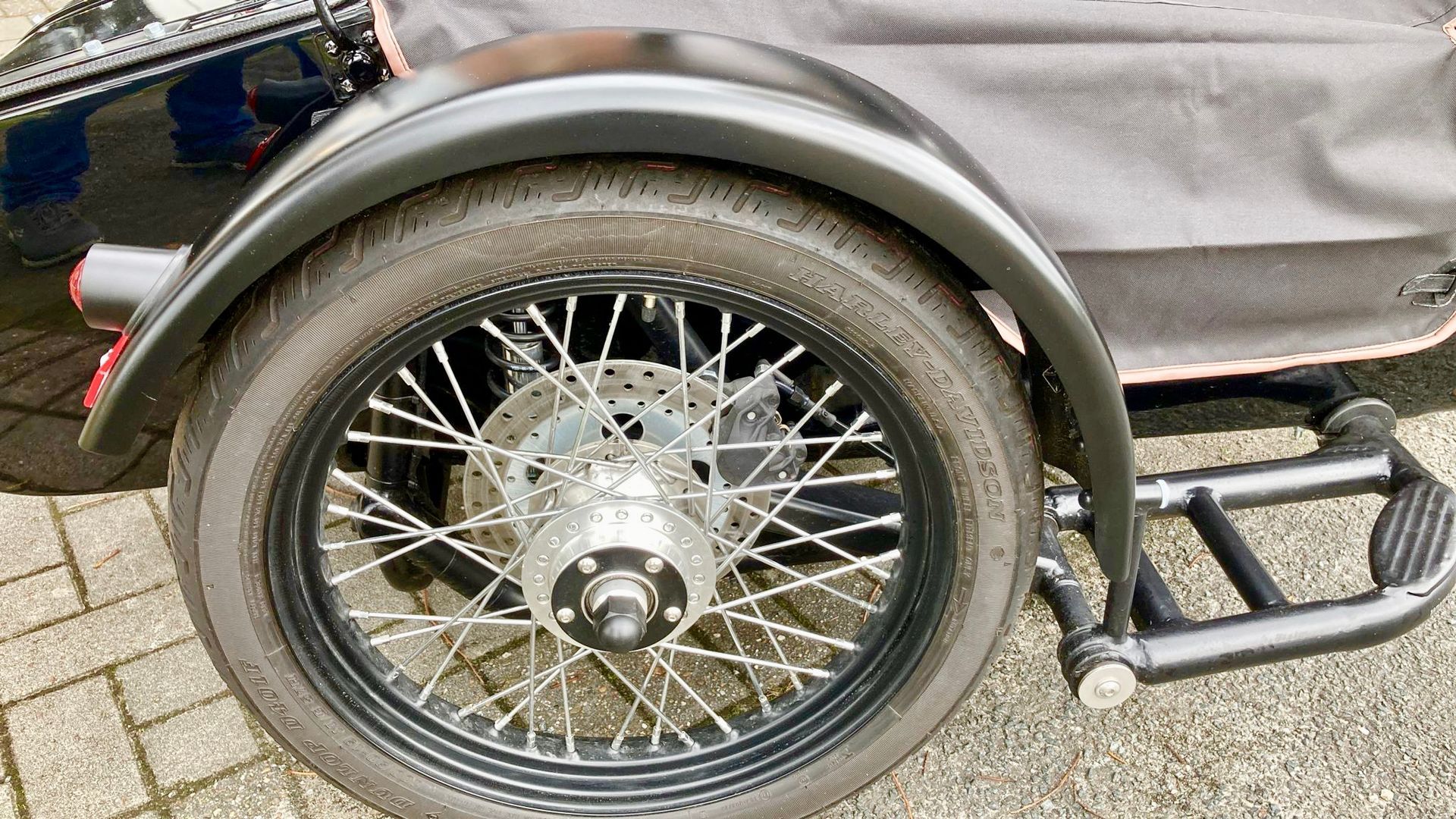 Eine Nahaufnahme eines Motorradrads mit einem daran befestigten Beiwagen.