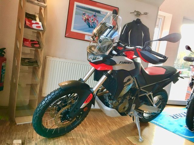 Ein rot-weißes Motorrad ist in einem Raum geparkt