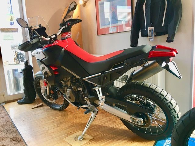 Ein rot-schwarzes Motorrad ist in einem Raum geparkt