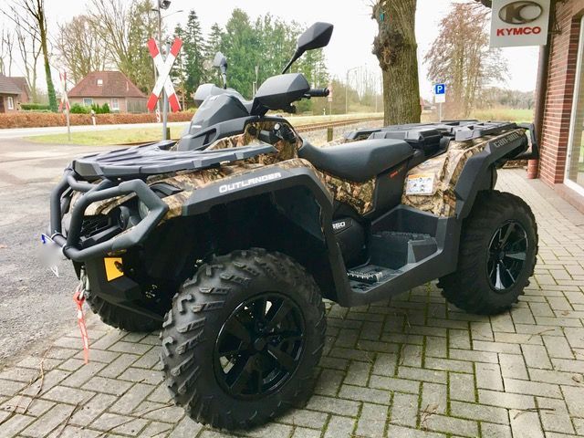 Auf einem gepflasterten Gehweg vor einem Gebäude ist ein Geländefahrzeug geparkt.