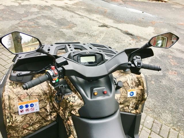 Ein getarntes Geländefahrzeug ist am Straßenrand geparkt.