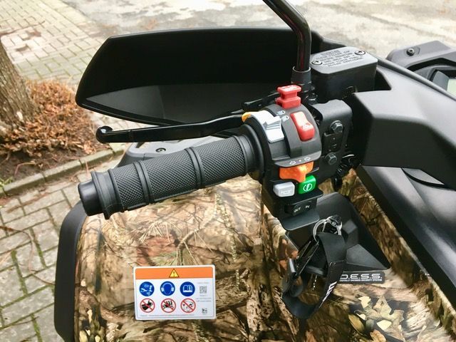 Eine Nahaufnahme des Lenkers eines Motorrads mit einem Warnschild darauf.