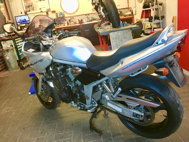 Ein silber-schwarzes Motorrad steht in einer Garage