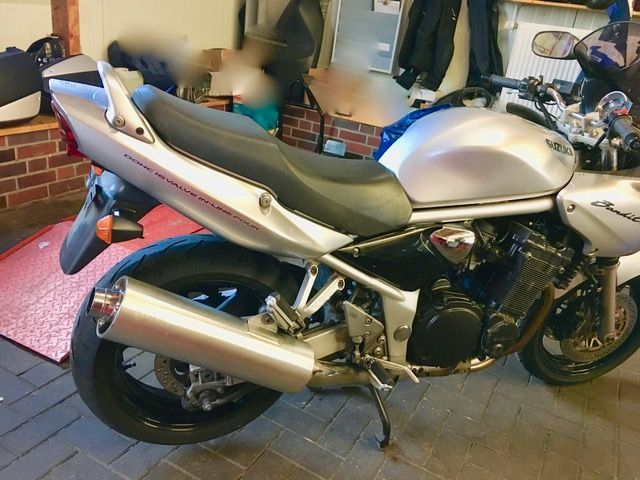 Ein silber-schwarzes Motorrad steht in einer Garage