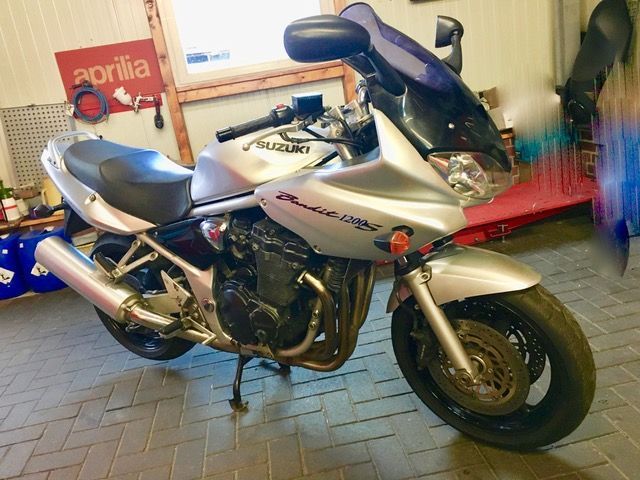 Ein silbernes Suzuki-Motorrad steht in einer Garage
