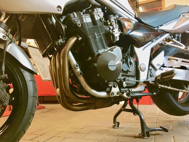 Ein Motorrad ist auf einem Ziegelboden in einer Garage geparkt