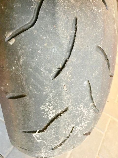 Eine Nahaufnahme eines Motorradreifens auf einem Fliesenboden.