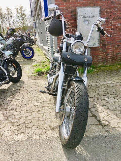 Ein Motorrad ist vor einem Backsteingebäude geparkt