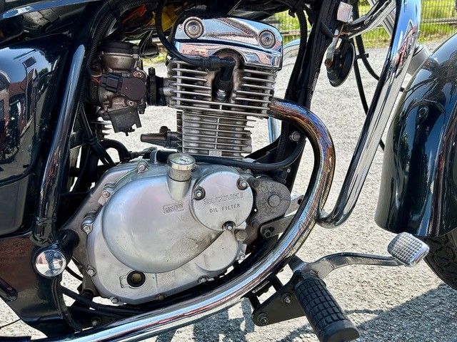 Eine Nahaufnahme des Motors eines am Straßenrand geparkten Motorrads.