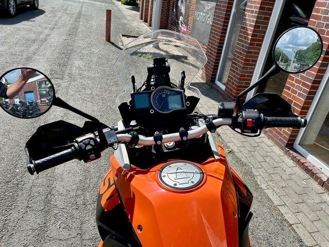 Ein Motorrad ist am Straßenrand vor einem Backsteingebäude geparkt.