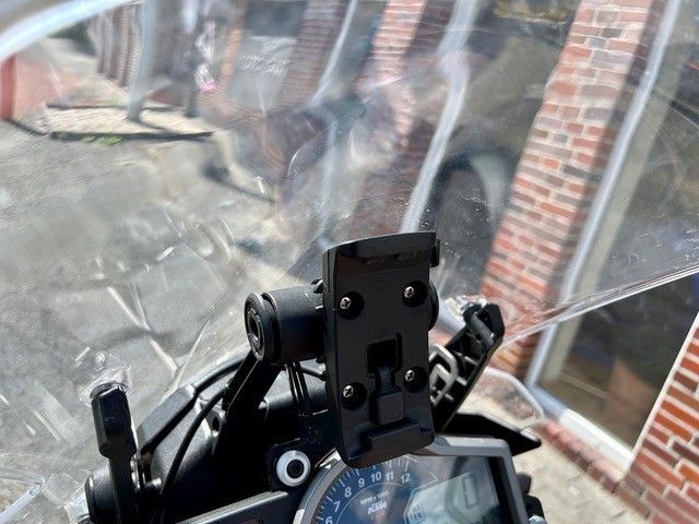 Ein Motorrad mit einer an der Windschutzscheibe befestigten Handyhalterung.