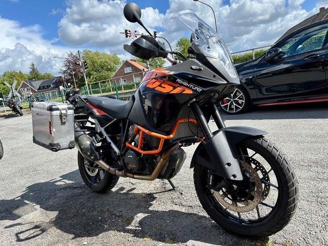 Auf einem Parkplatz steht neben einem Auto ein Motorrad.