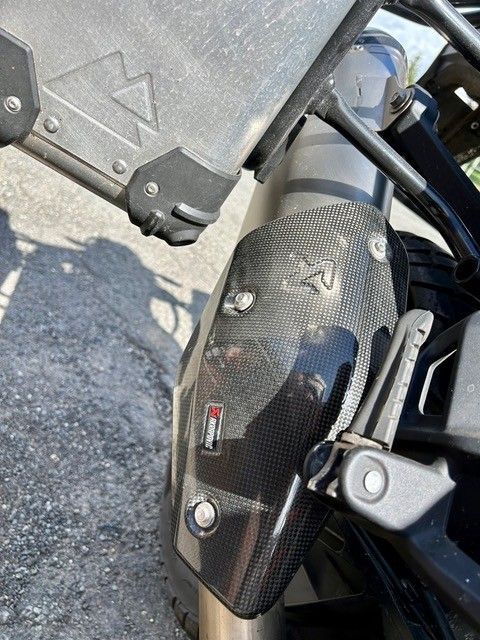 Eine Nahaufnahme des Auspuffs eines Motorrads auf einer Straße.