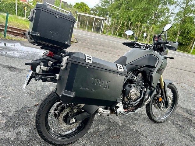 Schwarzes Yamaha-Tourenmotorrad mit Seitenkoffern und Topcase, geparkt auf nassem Asphalt im Freien