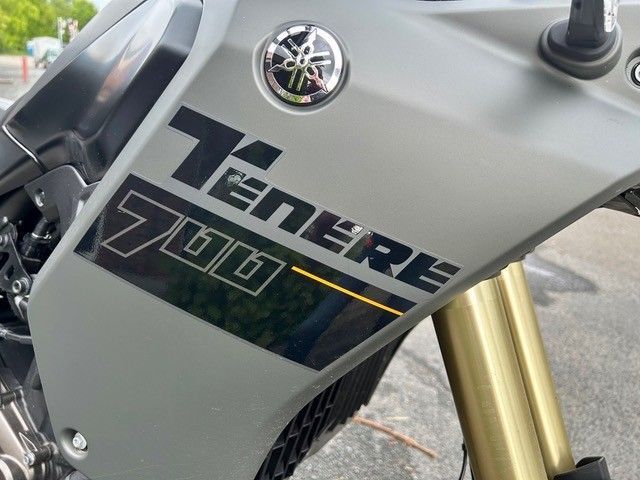 Nahaufnahme einer grauen Yamaha Ténéré 700 Motorradverkleidung mit Logo und goldener Vordergabel
