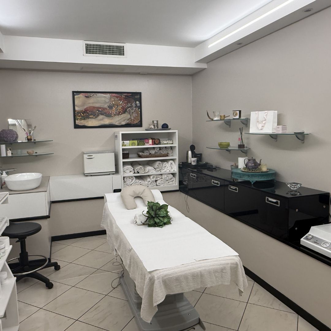 Sala per trattamenti termali con lettino per massaggi, scaffalature e attrezzature.