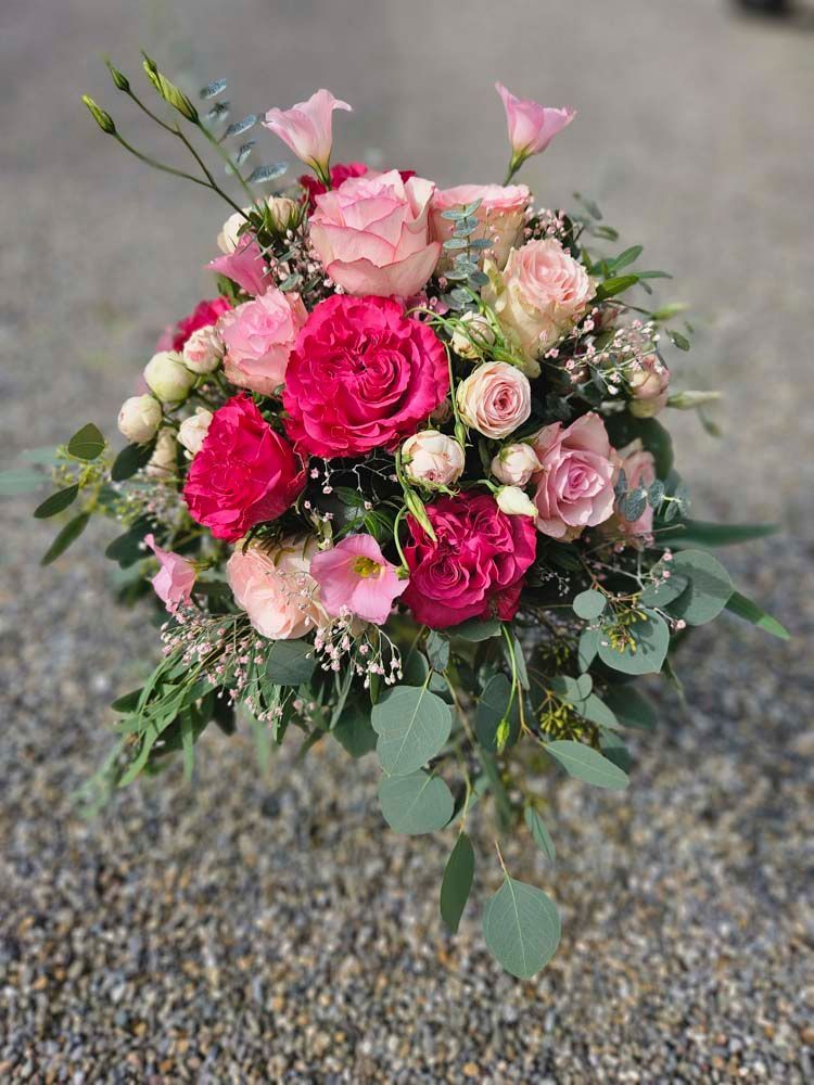 Auf dem Boden liegt ein Strauß rosa Blumen.