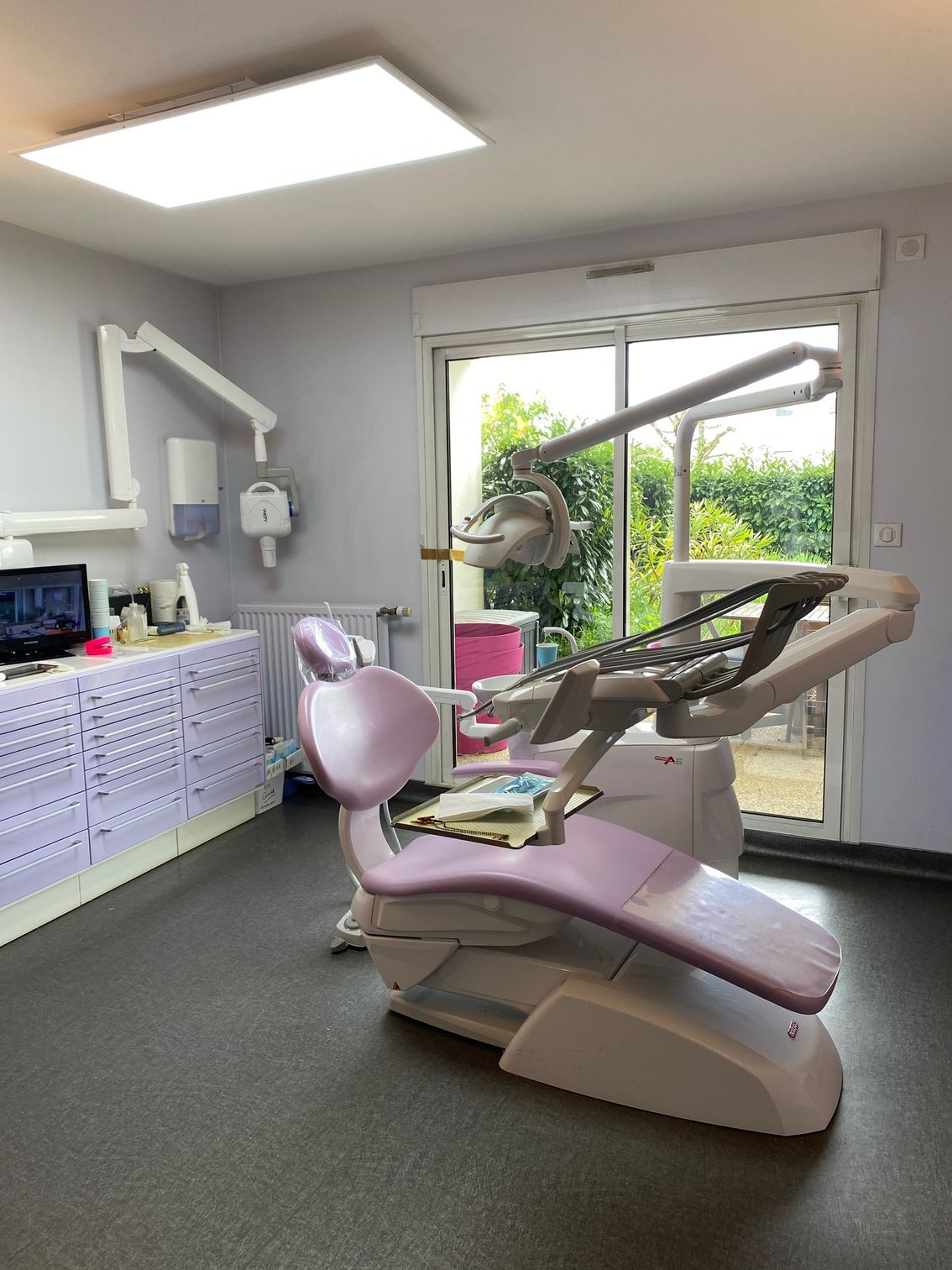 Salle du dentiste avec un fauteuil et l'équipement.