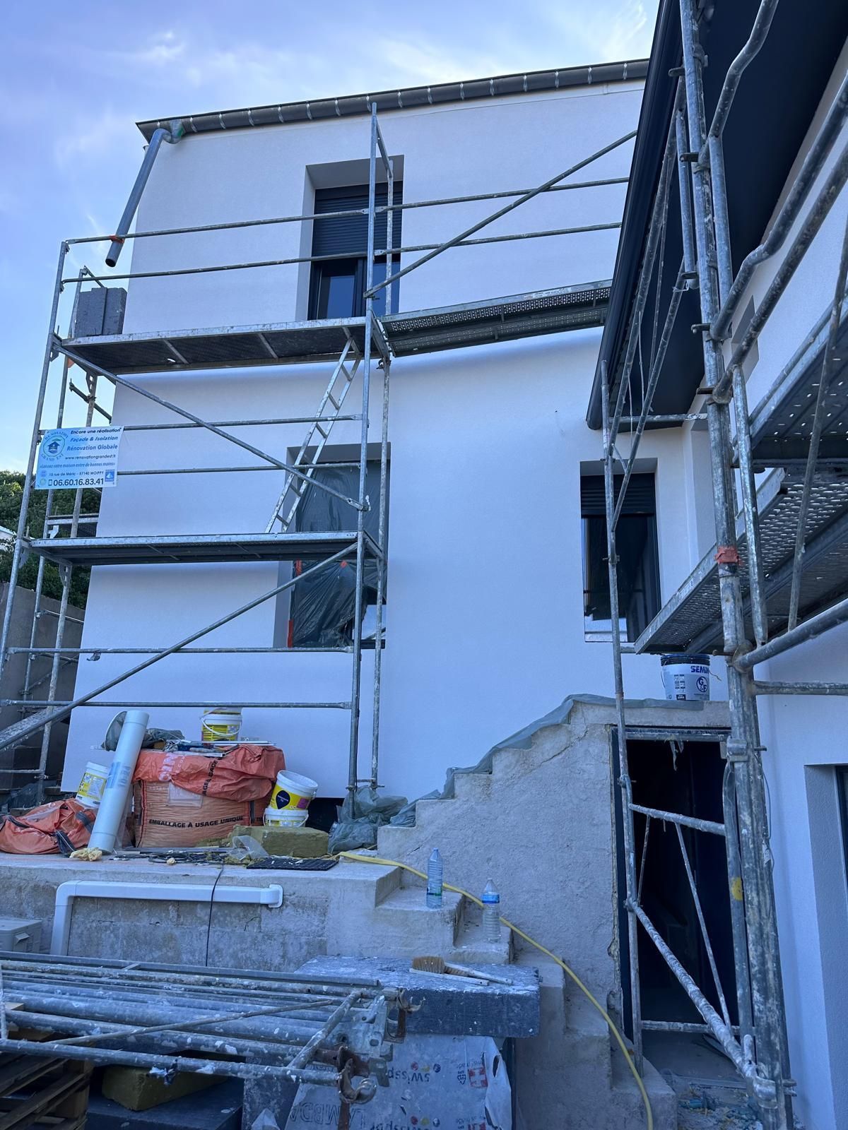 Extérieur d'un bâtiment blanc avec échafaudage, en construction.