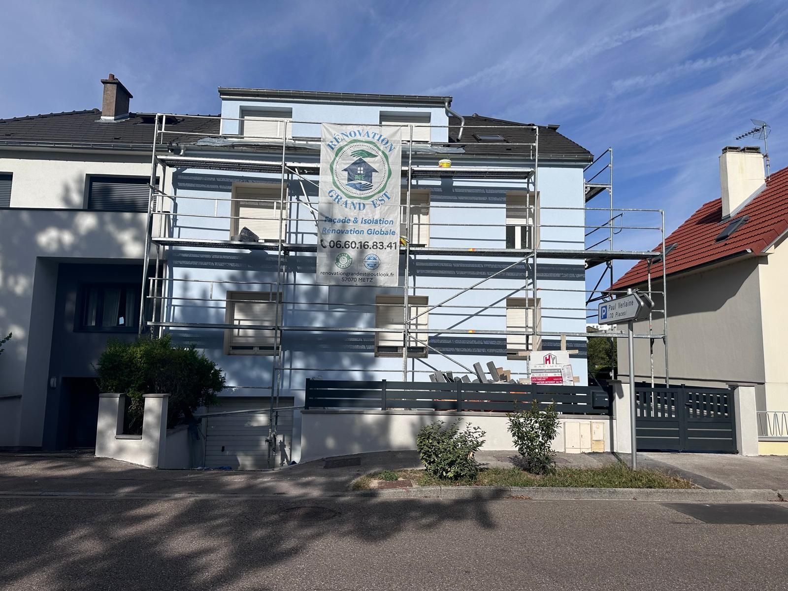 Bâtiment bleu en rénovation, échafaudage, bannière d'entreprise.