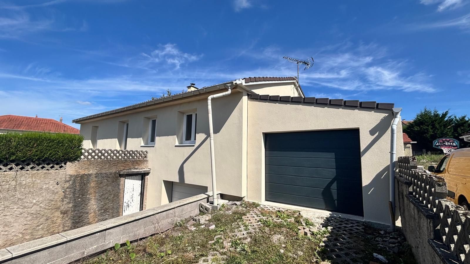 Maison beige avec garage.