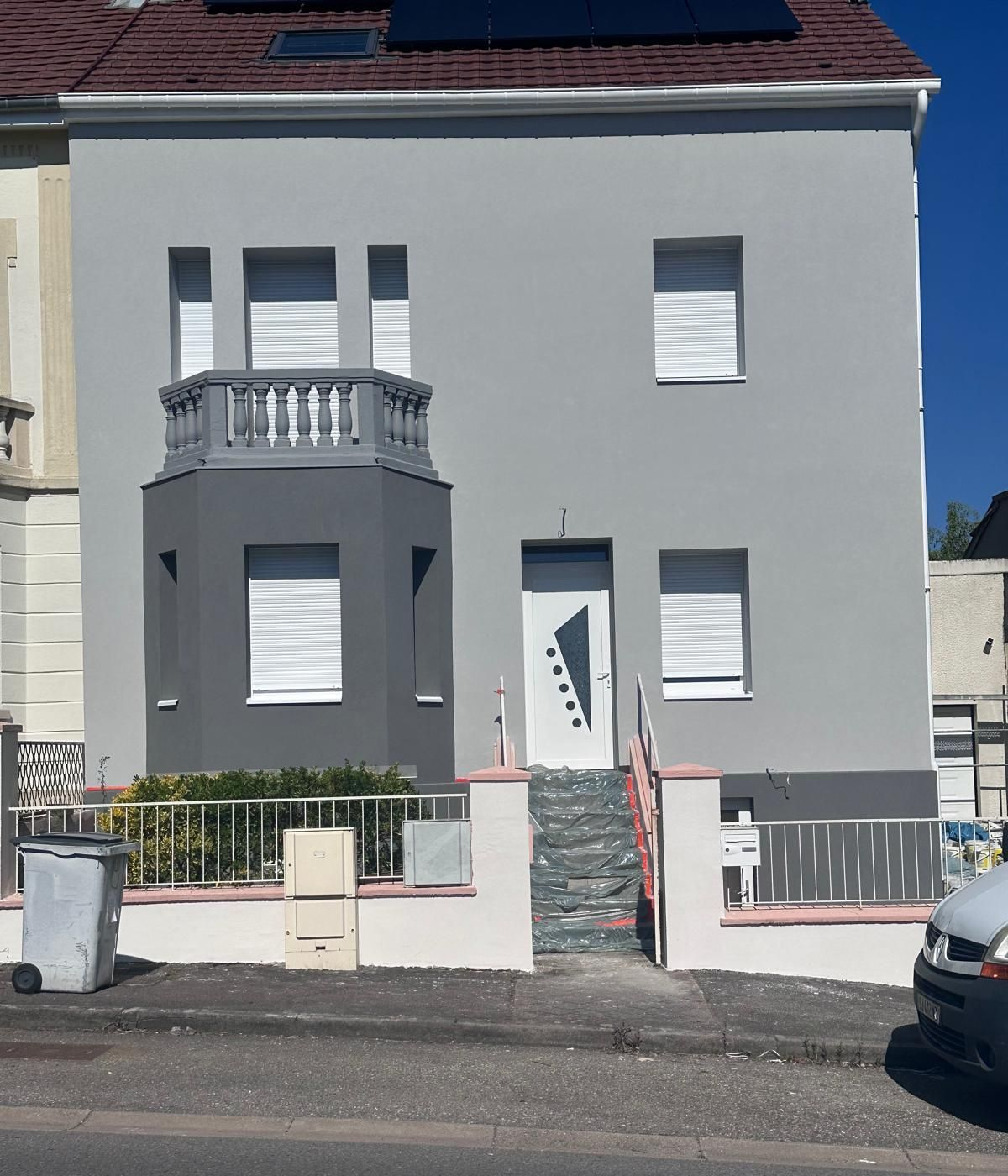 Maison avec balconnet gris.