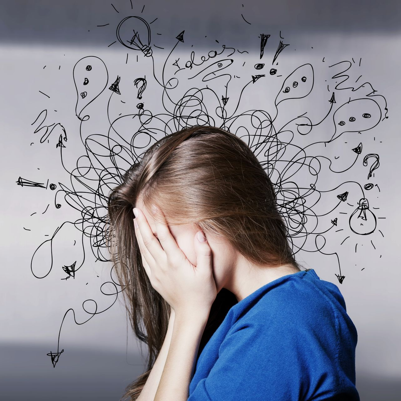 Femme la tête entre les mains, entourée de lignes et de symboles dessinés.