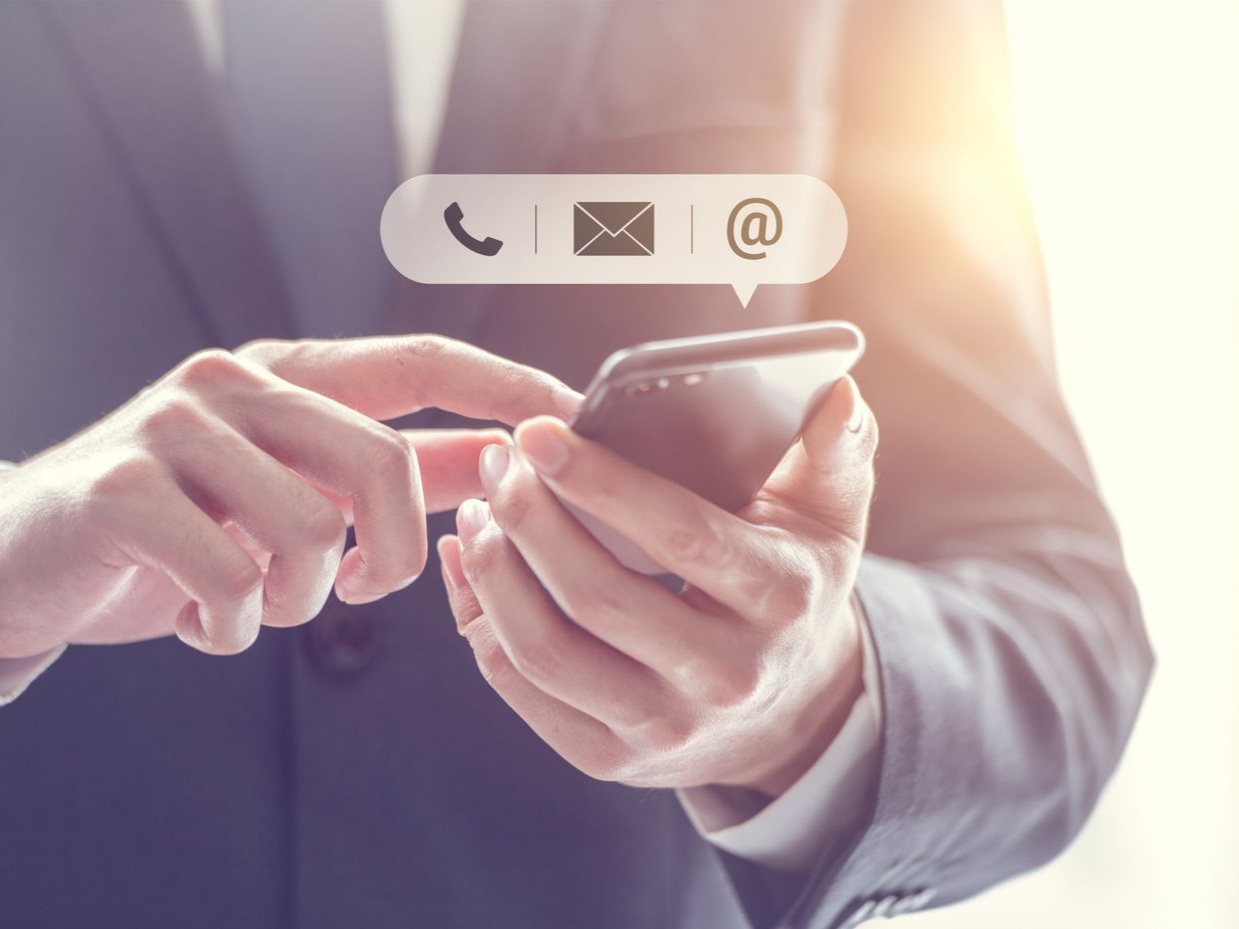 Une personne en costume utilise un smartphone.