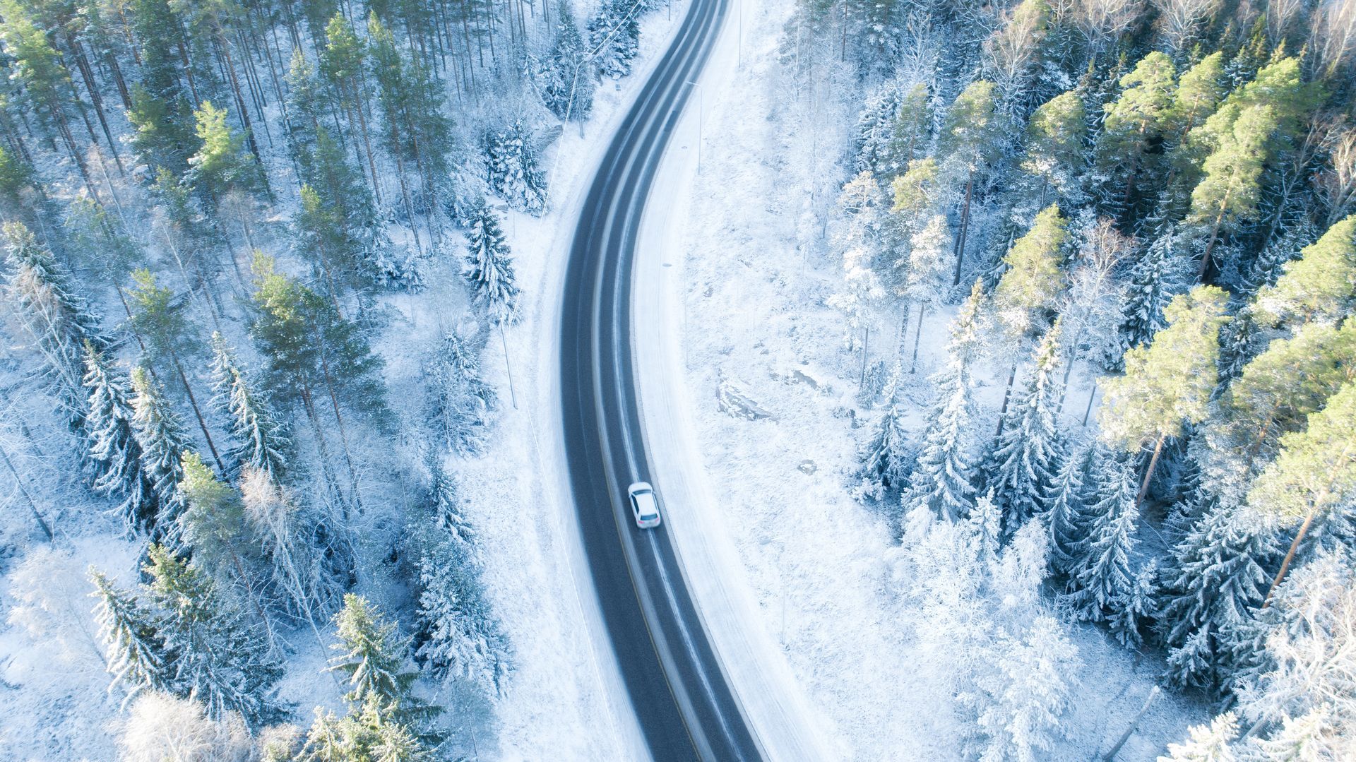 Voiture sur une route sinueuse par temps de neige