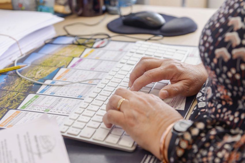Zoom sur les mains d'une femme tapant sur un clavier d'ordinateur