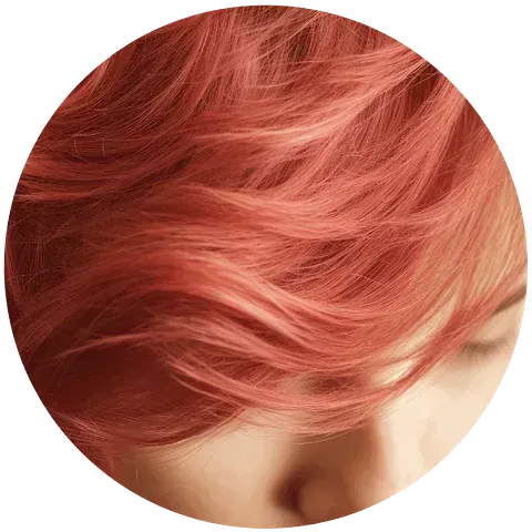 Primer plano del rostro de una persona; cabello corto, de color naranja rojizo, cubre gran parte del encuadre, con los ojos cerrados.